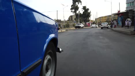 Blue-Taxi-Car-Driving-On-The-Street-In-Addis-Ababa,-Ethiopia