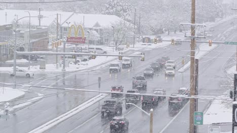 A-busy-intersection-with-cars-turning-left-and-others-waiting-during-a-cold-snowstorm-causing-slick-roads-in-December-of-2022-in-Midvale,-Utah