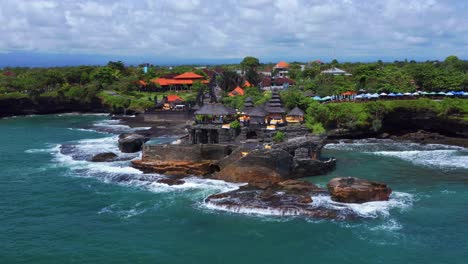 Ocean-Waves-Breaking-On-The-Tanah-Lot-Temple-In-Bali,-Indonesia---aerial-shot