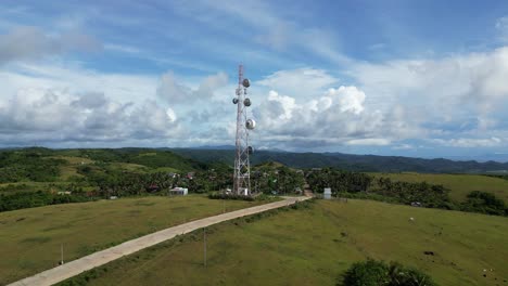 Atemberaubende-Drohnenaufnahme-Beim-Anflug-Auf-Einen-Satellitenturm-Neben-Einem-Tropischen-Philippinischen-Dorf-Und-Straßen-In-Catanduanes,-Bicol