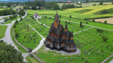 Stabkirche-Heddal-Und-Grabsteine-In-Vestfold-Und-Telemark,-Norwegen,-Skandinavien---Luftaufnahme-Rückwärts