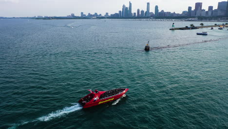 Aerial-view-panning-over-a-tour-boat,-revealing-the-skyline-of-Chicago,-sunny-USA