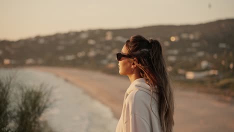Beautiful-Lady-Wearing-Sunglasses-Walking-To-Watch-Sunset-In-Cool-Wind