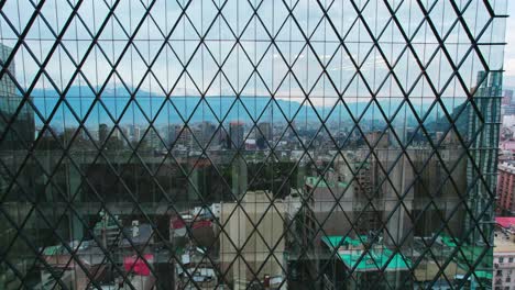 Luftaufnahme-Der-Spiegelung-Der-Stadt-Santiago,-Chile-In-Einem-Riesigen-Glas-Eines-Rautenförmigen-Gebäudes-An-Einem-Bewölkten-Tag,-Moderne-Architektur