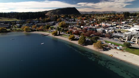 Aerial-cityscape-of-Wanaka,-picturesque-resort-town-on-lake-in-New-Zealand,-during-Autumn-season