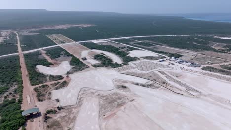 Aerial-backwards-shot-of-large-construction-site-field,-project-for-new-hotels-and-resorts-at-cabo-rojo-port-in-Pedernales