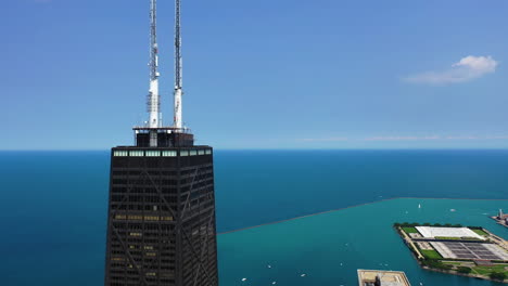 Aerial-view-circling-the-John-Hancock-center,-sunny-day-in-Chicago,-Illinois,-USA