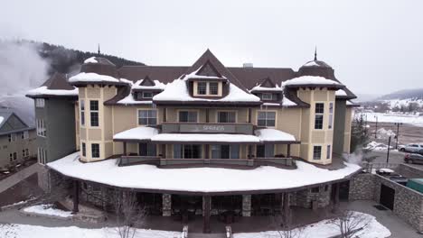 Aerial-View-of-Pagosa-Hot-Springs-Resort-Main-Building-on-Winter-Day,-Colorado-USA,-Revealing-Drone-Shot