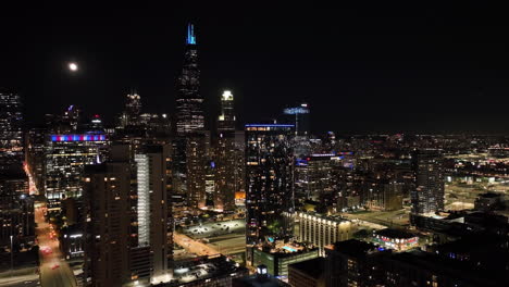 Drohnenaufnahme,-Die-Die-Beleuchtete-Skyline-Von-Chicago-Loop-Von-Der-Westseite-Aus-Umkreist