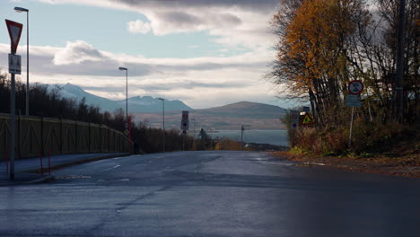 Land-Vehicles-Driving-And-Pedestrians-Walking-On-The-Street-On-An-Autumn-Day-In-Tromso,-Norway