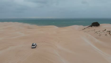 White-4x4-car-driving-on-dunes-at-Western-Australia,-aerial
