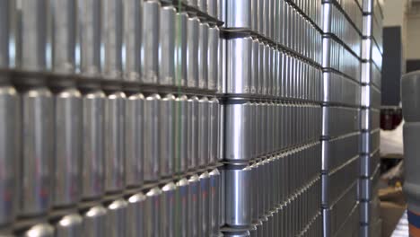 Pallets-of-unmarked-aluminum-beer-cans-in-brewery-warehouse,-close-up