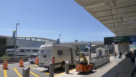 Ground-Crew-Towing-Luggage-Pushcarts-Drives-Outside-Airport-Terminal