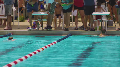 Nadadores-Jóvenes-Corriendo-Hasta-La-Línea-De-Meta-En-La-Piscina