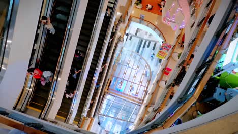 Bangkok-Shopping-Mall-High-Angle-View-Looking-Down-at-Escalators-with-Multiple-Floors,-Thailand