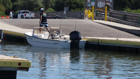 Man-putting-small-boat-in-at-boat-dock