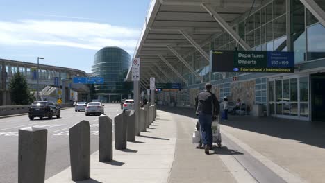 Passenger-Hurries-with-Luggage-Cart-to-Vancouver-Airport-Terminal-FOLLOW-BEHIND