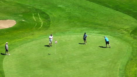 Group-of-four-men-playing-a-round-of-golf-at-prestigious-country-club-in-USA
