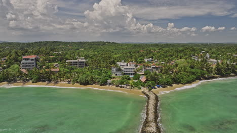 Mirissa-Sri-Lanka-Aerial-v1-reverse-flyover-Fishery-Harbor-Secondary-Breakwater-capturing-exotic-landscape-of-Bandaramulla-beach-and-resort-hotels-along-the-shore---Shot-with-Mavic-3-Cine---April-2023