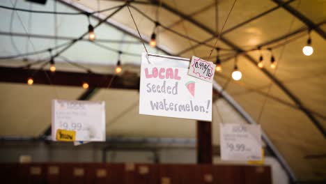 Auf-Einem-Hängenden-Schild-Auf-Einem-Lokalen-Sommermarkt-Für-Vegane-Bio-Bauern-Steht:-Lokale-Wassermelone-Mit-Samen-Wird-In-St.-Leon-Gardens,-Winnipeg,-Manitoba,-Kanada,-Zum-Verkauf-Angeboten