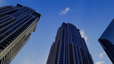 Blick-Aus-Der-Würmerperspektive-Auf-Den-College-Park,-Doppeleigentumswohnung,-Futuristisches-Design,-Glas,-Das-Sich-Gegenseitig-Spiegelt,-Während-Die-Wolken-An-Einem-Sonnigen-Tag-Vorüberziehen.-Ansicht-Von-Unten-Von-Oben-Auf-Das-Architektonische-Wunder-Der-763-Und-765-Bay-Und-Des-Colleges-An-Der-Yonge-Street