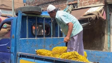 Arbeiter-Aus-Bangladesch-Auf-Einem-Lastwagen,-Der-Große-Säcke-Mit-Zutaten-Auf-Der-Belebten-Straße-Verwaltet