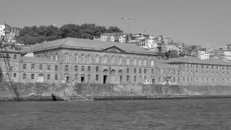 Alte-Und-Historische-Gebäude-Am-Flussufer-Von-Porto,-Portugal,-Gesehen-Von-Einem-Boot-Aus,-Das-Auf-Dem-Fluss-Douro-Fährt