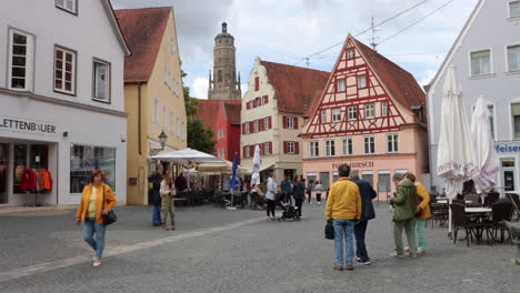 Locals-Walking-In-The-Schrannenstrasse-Street-Surrounded-By-Restaurants-And-Shops-in-Nordlingen,-Germany