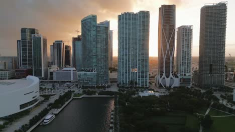 Grupo-De-Rascacielos-Sobre-El-Horizonte-Del-Atardecer,-Vista-Aérea-De-La-Ciudad-Americana-Del-Centro-De-Miami,-Yates-Y-Parque-Urbano