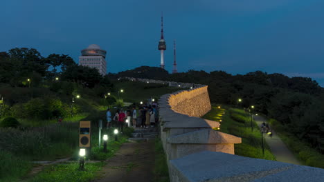 Menschen-Im-Seouler-Stadtpark-Mit-Einer-Alten-Mauer-Und-Dem-Namsan-Turm-Dahinter-Tagsüber-Bis-Zur-Abenddämmerung-In-Seoul,-Südkorea