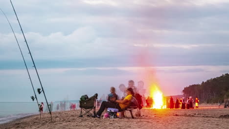 Timelapse-De-Una-Fogata-En-La-Playa-Con-Un-Grupo-De-Personas-Celebrando-Y-Pescando-A-Lo-Largo-De-La-Costa-Arenosa