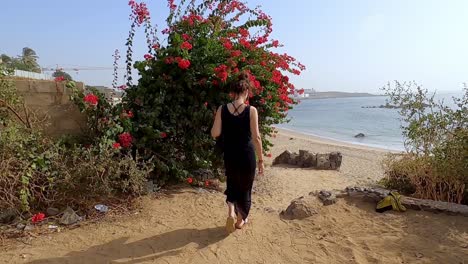 Parte-Trasera-De-Una-Mujer-Atractiva-Caminando-Hacia-La-Playa-En-Senegal,-África