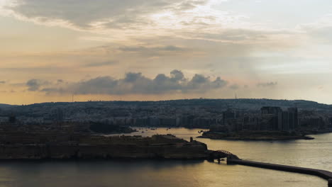 Aerial-view-around-the-St-Elmo-fort-and-the-Valletta-cityscape,-sunset-in-Malta