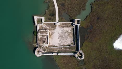 Außergewöhnliche-Mittelalterliche-Burg,-Historisches-Juwel,-Umgeben-Von-Türkisfarbenem-Wasser-An-Der-Flachen-Lagune-Von-Butrint,-Blick-Von-Oben