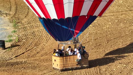 Sightseers-landing-in-rural-field-on-a-hot-air-balloon-during-festivals-in-the-USA