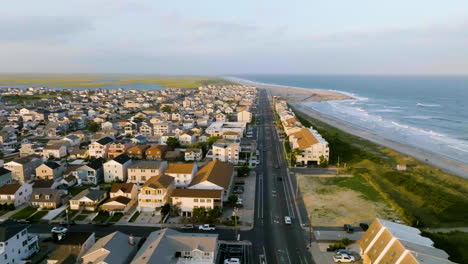 Aerial-tracking-shot-overlooking-the-Brigantine-neighborhood-and-beach,-golden-hour-in-New-Jersey,-USA