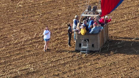 People-landing-in-hot-air-balloon-in-rural-field-in-USA