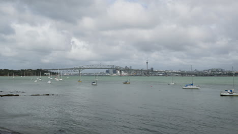 Zeitraffer-Mit-Blick-Auf-Auckland-Mit-Yachten-Und-Stadthafenbrücke-Im-Hintergrund-An-Einem-Bewölkten-Tag-In-Neuseeland