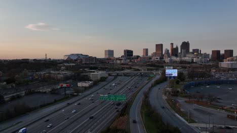 Downtown-Atlanta-Freeway,-Interchange-with-the-view-of-famous-skyline-buildings-in-the-background-at-sunset,-Aerial-View