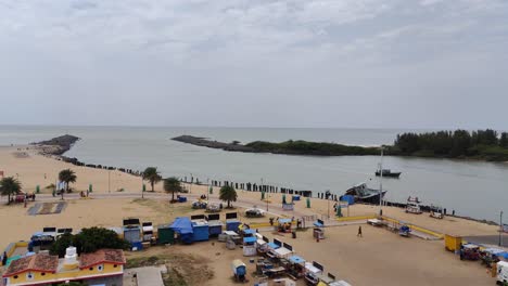 Luftaufnahme-Der-Flussmündungen-Des-Arasalar-Mit-Der-Bucht-Des-Bengalischen-Ozeans,-Blick-Auf-Den-Strand-Mit-Touristen,-Die-Vom-Leuchtturm-Aus-Streifen