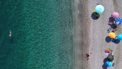 Aerial-top-down-view-static-of-Manilva-Marbella-beach,-turquoise-crystal-clear-water-in-Estepona,-tropical-vacation-relaxing-holiday-in-Malaga-Spain,-umbrellas,-copy-space-and-room-for-text,-4K-shot
