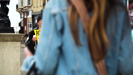 concerned-citizen-of-Asian-background-is-protesting-in-the-UK-against-agenda-the-government-has-to-strip-us-of-our-rights-and-steal-our-farms-homes-and-human-rights-he-is-holding-yellow-sign-by-road