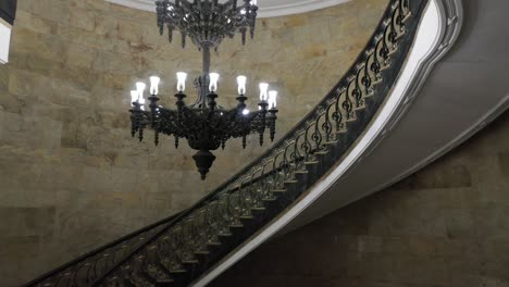 Antique-Lit-Chandelier-At-The-Empty-Hall-Near-Staircase-At-The-Ministry-Of-Treasure-Building-In-Rio-de-Janeiro,-Brazil