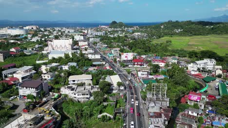 Stunning-flyover-shot-of-Philippine-provincial-town-with-bustling-streets-and-buildings-in-Legazpi,-Albay