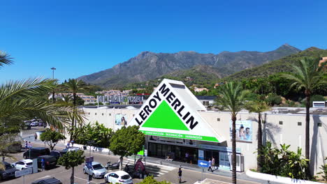 Luftaufnahme-Des-Baumarkts-Und-Gartenbaugeschäfts-Leroy-Merlin-Mit-Blick-Auf-Die-Berge,-Großer-Baumarkt-Mit-Palmen-In-Marbella,-Málaga,-Spanien,-4K-Aufnahme