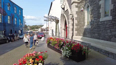 Altstadt-Von-Waterford,-Stadtuhrenmuseum-Mit-Leuchtenden-Blumen-Und-Menschen-Im-Frühsommer