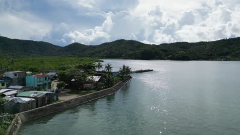 Drohnenaufnahme-Einer-Ruhigen-Küstenstadt-Mit-Atemberaubender-Wolkenlandschaft-Und-Unberührtem-Wasser-In-Baras,-Catanduanes