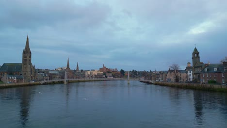 Forwards-fly-above-Ness-river-with-its-bridges-in-historic-city-centre-in-Inverness