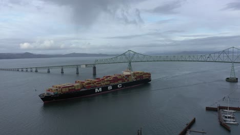 El-Buque-De-Carga-Msc-Viaja-Por-El-Río-Columbia-Debajo-Del-Puente-Astoria-Megler-En-Astoria-Oregon,-Vista-Aérea-De-Drones