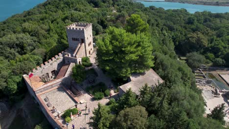 Butrint-Tower-of-Castle-Atop-the-Hill-in-the-Ancient-Roman-City,-a-UNESCO-Site-Revered-by-Tourists-and-History-Enthusiasts